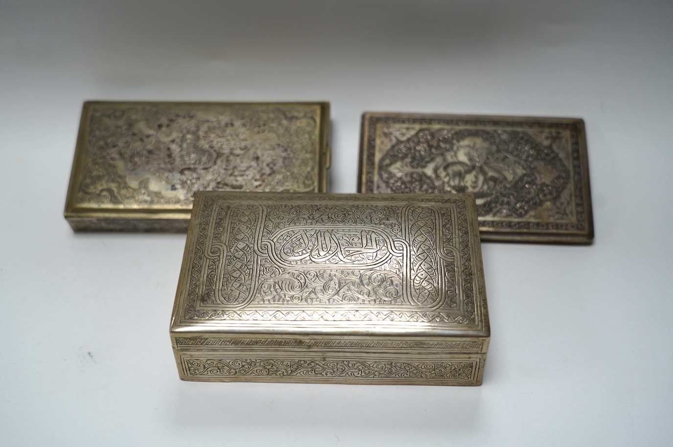 An Egyptian white metal cigarette box, 14,5cm, a Persian white metal cigarette box and similar cigarette case, gross weight 26.6oz. Condition - poor to fair